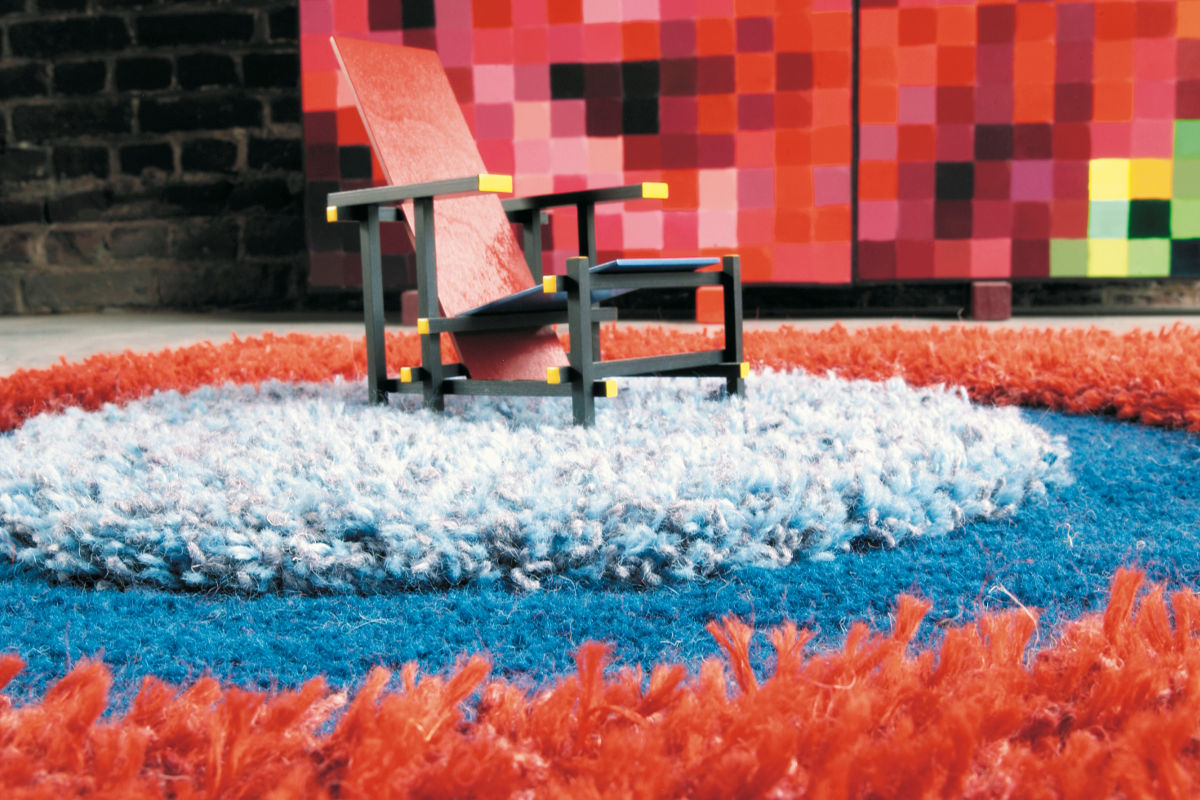 De Rietveld stoel op rond fel gekleurd gestreept hand tuffed tapijt